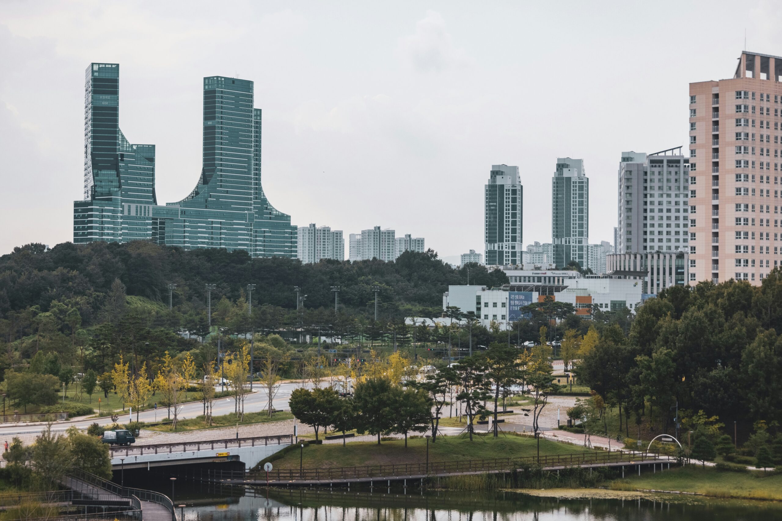 Sejong-si cityscape with modern government buildings, apartment towers, green parks, and a waterfront area in South Korea.